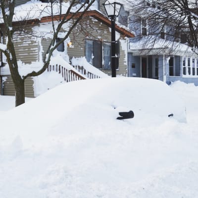 En bil begraven i snön.
