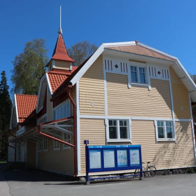 Grankulla tågstation en solig dag. Stationen är ett gult trähus.