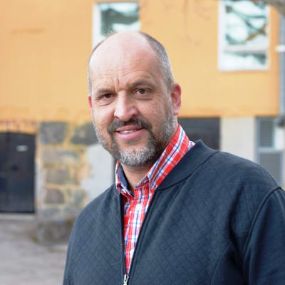 Ett porträtt på en man iklädd skjorta och tröja. Mannen heter Sture Lindholm 