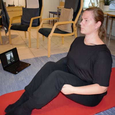 Syöpää sairastava Sonja Alanko jumppaa läppärin edessä.