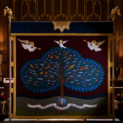 En broderad skärm med ett träd med 56 namngivna blad. Ovanför trädet syns två ängar och en duva. Nedanför trädet finns kung Charles III:s emblem och en textrad: "All shall be well and all manner of thing shall be well"