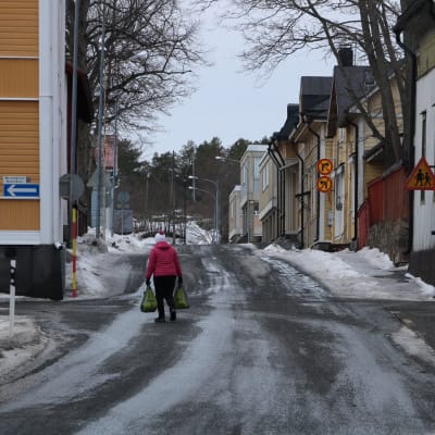 En ensam kvinna går på en gata.
