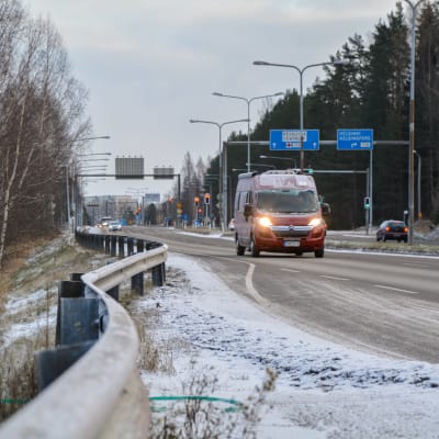 Skåpbil kör på stor väg. 