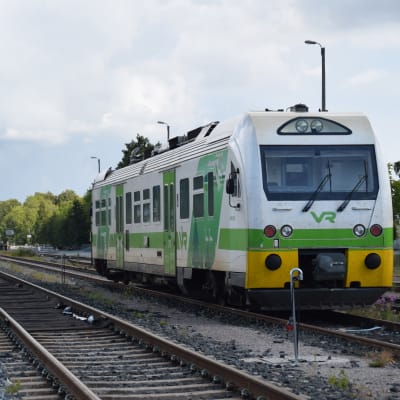 En rälsbuss står och väntar på ett järnvägsspår.