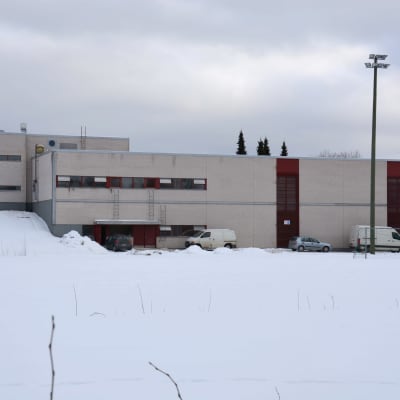 Skolbyggnad i snöigt landskap.