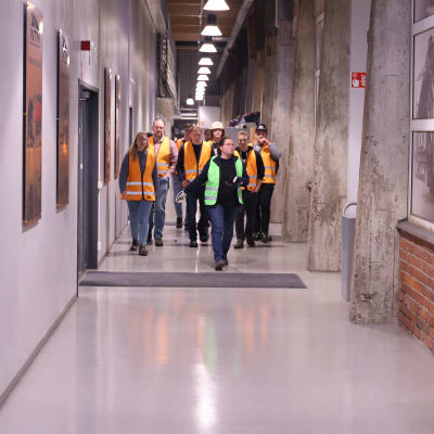 En grupp med människor går i en korridor.