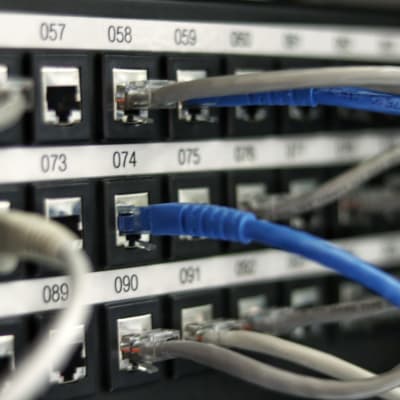 Bild på numrerade datakablar in i serverportar.