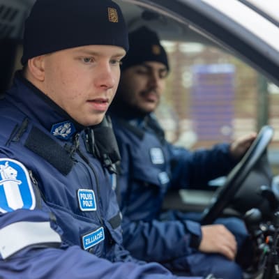 Polisstudenterna Matias Zilliacus (till vänster) och Gabriele Tasco i förarsätet till en polisbil vid polisyrkeshögskolan i Tammerfors.