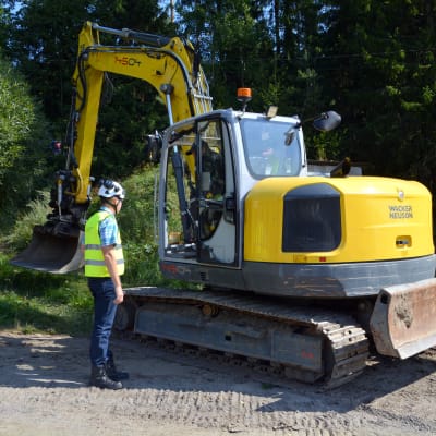 En grävmaskin gräver ner markkabel i Saxby