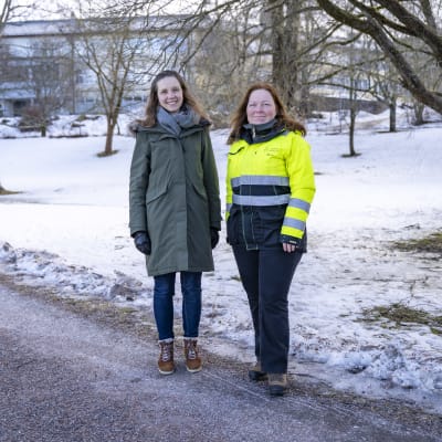 Elena Horttana och Maria Eriksson står vid en snöig brant där det ska byggas en lekpark i Karis.