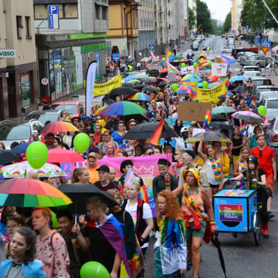 färgglada paraplyer och en massa människor som går i åbos prideparad 2018