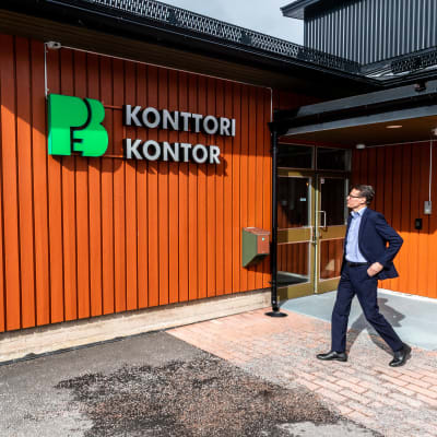 Måns Holmberg utanför kontorsbyggnad i rött.