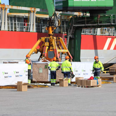 Hamnarbetare hjälper till med lastningen av ett fartyg i Kaskö hamn.