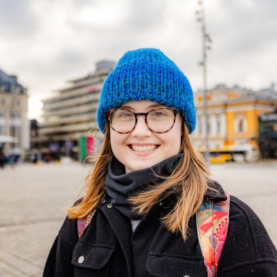 Kvinna i blå mössa på Åbo salutorg.