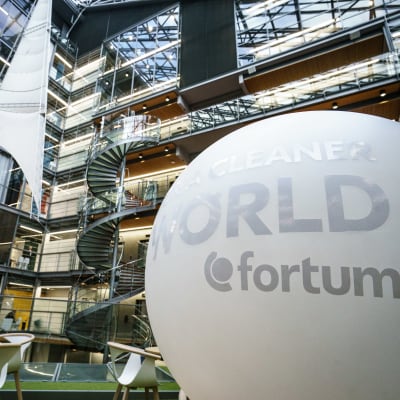 Fortumin pääkonttorin aula Keilaniemessä. Etualalla iso valkoinen pallo, jossa teksti: For a cleaner world, Fortum.