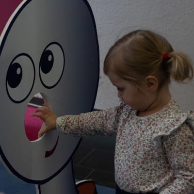 BUU-dagen i Hfors 2019. En liten flicka kastar en boll igenom en paff-buustämpel