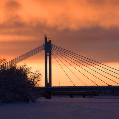Jätkänkynttilä-silta Rovaniemellä kuvattuna kaamoshämärässä, taivas on punertava.