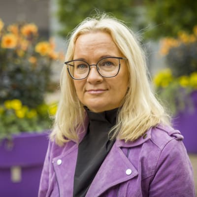 Päivi Niemi-Laine seisoo suurten kukkaruukkujen edessä.