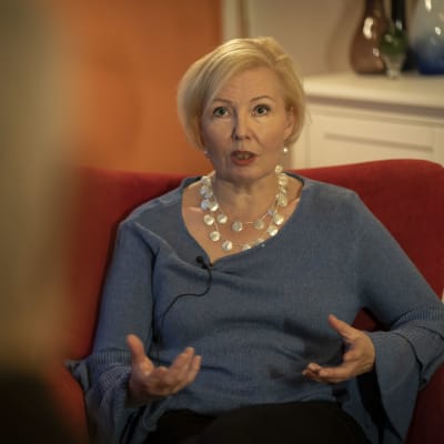 Tiina Parikka istuu nojatuolissa, kasvot katsojaan päin.