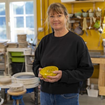 Kvinna med en gul skål i handen.
