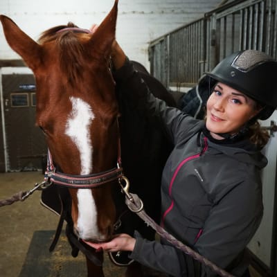 Reeta Hämäläinen i stallet med hennes häst.