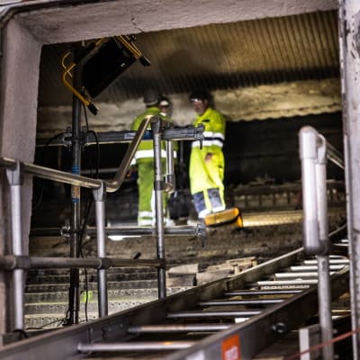 Arbetare rengör insidan av förbränningsugn