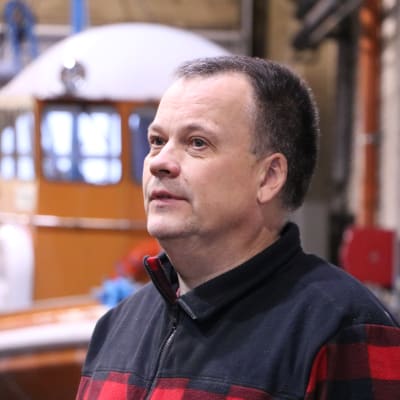 En medelålders man med aningen grått kort hår står inne i en verkstad.