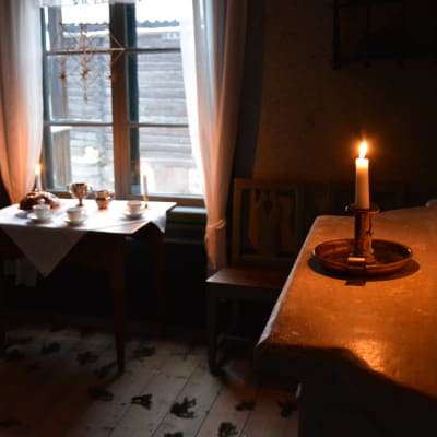 Ett ljus brinner i ett av stugorna i Klosterbacken. 