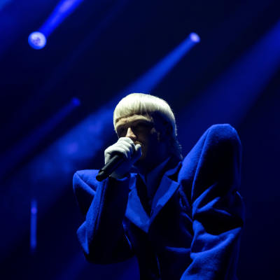 Artisten Joost Klein uppträder på scen, upplyst av blått ljus.
