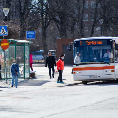 Personer stiger av och på en buss på Borgå torg.