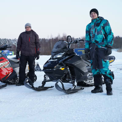 Mats Nyberg och John Björklöf står bredvid sina snöskotrar.