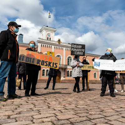 Demonstration med plakat på torget i Lovisa.