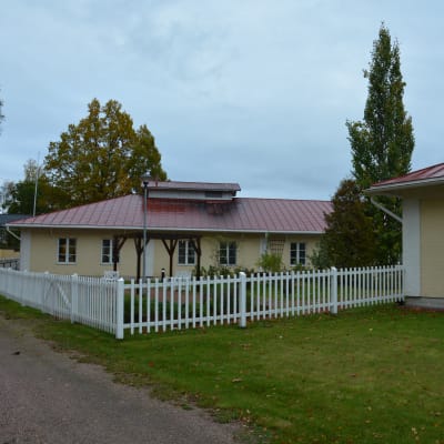 Låg byggnad med staket. 