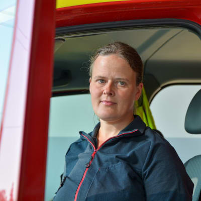 Johanna Nyholm vid en dörren till en brandbil. 