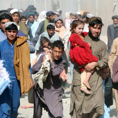 Afganistanilaisia rajalla menossa Pakistanin puolelle.