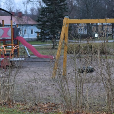 En lekpark tom på barn en höstlik, mulen och snöfri vinterdag i januari.