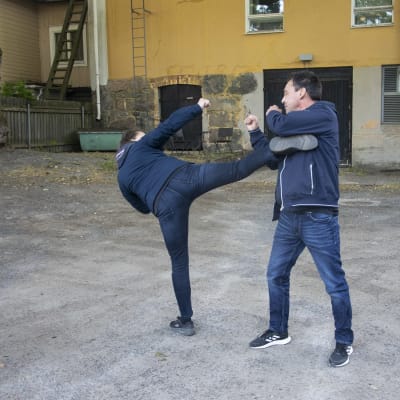 En person riktar en spark mot en annan.