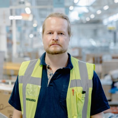 Aleksi Andersson seisoo Postin logistiikkakeskuksessa Vantaalla.