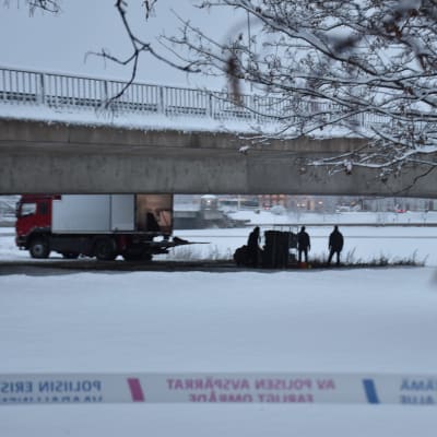 Poliisitutkinta sillan alla. Talvimaisema aamuhämärässä. 