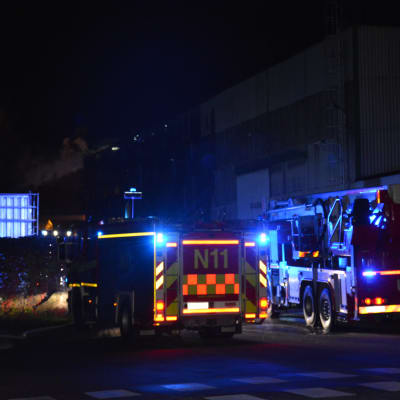 nattbild med brandbilar och rök i bakgrunden