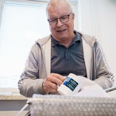 Verkkokauppayrittäjä Mikko Karppanen pakkaa mukia asiakkaalle lähettämistä varten.