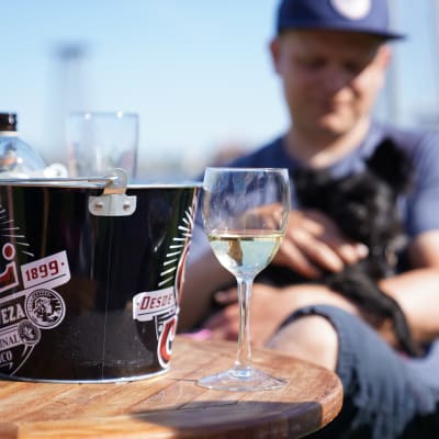 En man sitter på en uteservering med öl framför sig.