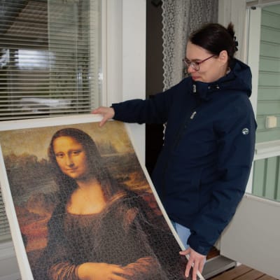 Kirsi Saari esittelee kokoamaansa Mona Lisaa esittävää isoa palapeliä