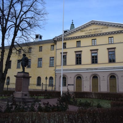 Åbo hovrätt består av en stor gul byggnad i tre våningar. Framför huset står en staty i parken.