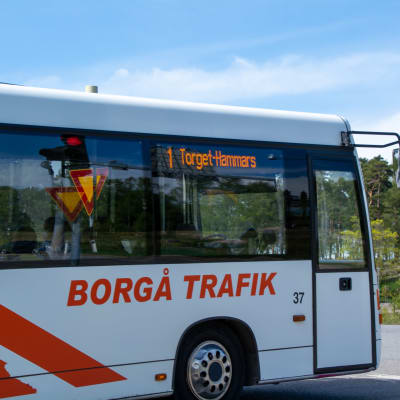 En vit buss med en Borgå trafik logo på sidan som står stilla. 