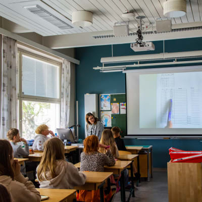 Janina Johansson framför sina elever i ett klassrum.