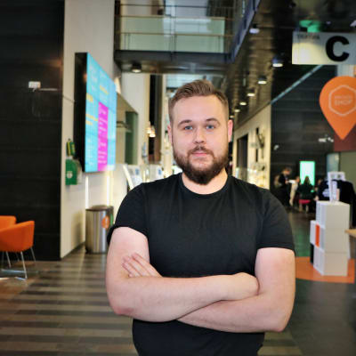 Elias Schulman står i gången på Arcada med händerna i kors.
