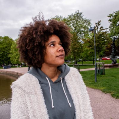 Akunna Onwen står vid Tokoi stranden och tittar mot horisonten.