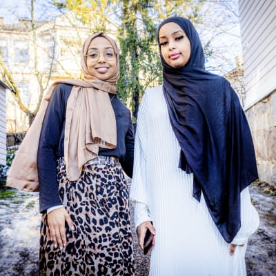två unga kvinnor i hijab kläder