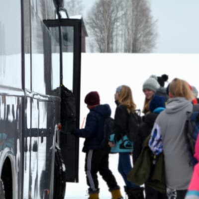 Elever stiger på buss.